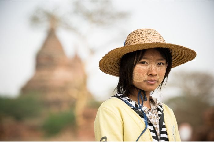 Burmese woman with hat and temple in background