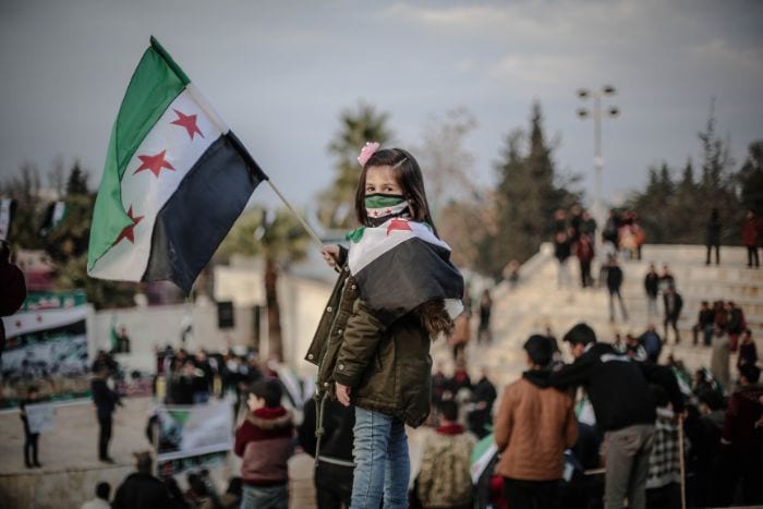 Syrian girl holding a Syrian flag